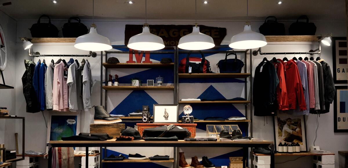 Boutique de vêtements, portants et étagères éclairés par des suspensions